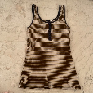 randigt linne  - gul/ljusbrun och svartrandigt linne med svarta knappar sitter väldigt fint! otroligt stretchigt material