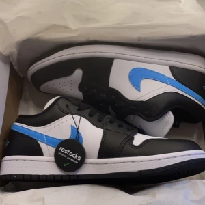 Air Jordan 1 Low - Air Jordan 1 Low i vit, svart och ljusblå. Storlek 39. Ganska välanvända och lite trasiga i hälen på högra skon. Skosnörena är även slitna men de går att byta. Välanvänt skick men ändå bra! Skolådan finns kvar💗