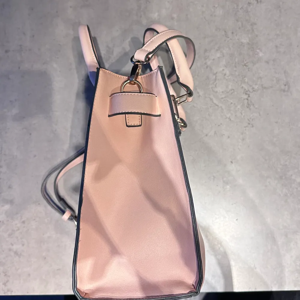 Jättefin rosa väska som är helt oanvänd!! Den har justerbart band och flera fack för mer plats!!Mått: 31cm (längd) x 25cm (höjd) x 14cm (bredd). Väskor.