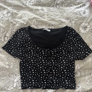 Topp - Svart topp med små vita blommor från Newyorker i storlek M  Nyskick