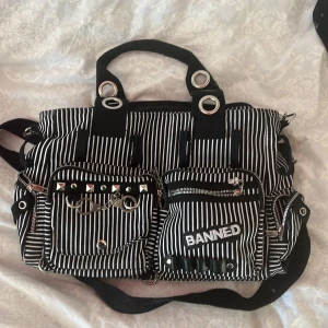 Väska med kedjor - En medelstor väska med många fickor. Den har kedjor och många detaljer. Den säljs pågrund av att det inte är min stil längre och den är i bra skick.