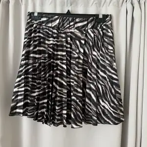 Kort kjol med veck. ”Zebra” mönster. Är som ”shorts” under. Använd fåtal gånger. Ganska liten i storlek upplever jag💕
