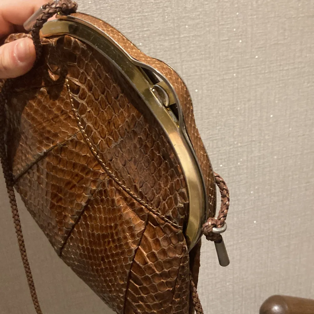 Jättefin brun axelväska i äkta ormskinn🤎 Fina guld detaljer! Unik form på väskan och perfekt att ha nu till sommaren🫶🏼 Superbra skick!. Väskor.