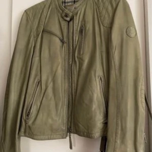Molltan grön skinnjacka - Mkt fin skinnjacka i toppskick. Lika fin till jeans som till blommig sommarklänning.  Mkt sparsamt använd.