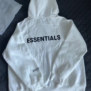 Vit Essentials Fear of god  - Hej, jag säljer den här helt nya oanvänd Essentials zip up eftersom den inte passar mig. Storlek är M fast den passar som L. 