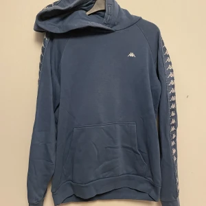 Blå/grå Kappa-hoddie - Knappt använd hoddie från Kappa, skulle säga att den är stl M!  Färgen är mer blå än vad som syns på bilderna, lite som jeansblå:)