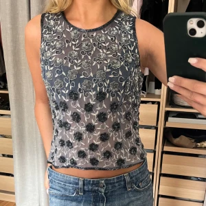Unik topp - Unik vacker topp med pärlor och paljetter. Dragkedja längs hela ryggen. Köpt secondhand, aldrig använd av mig. Väldigt bra skick. Skimrar/lyser väldigt fint i solen