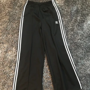 Baggy adidas byxor dam - Snygga adidas byxor i jätte bra skick! Använda 1 - 2 gånger Tvättar innan jag skickar ut! Kan även bäras som low waist. För referens är jag på bilden 171 cm lång. Säjer p.g.a. de inte kommer till användning.
