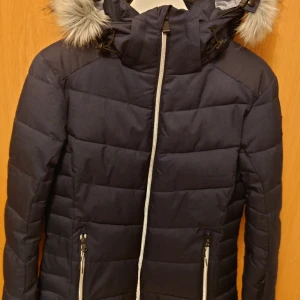 Vinter-/skidjacka McKinley  - Jackan är i nyskick och använd endast vid två tillfällen. Varmfordrad med avtagbar huva. Dragsko nertill samt snölås som också är avtagbart. Innerficka med dragkedja och snölås även vid ärmslut.  Normalstor i storleken, dvs motsvarar stl 38.