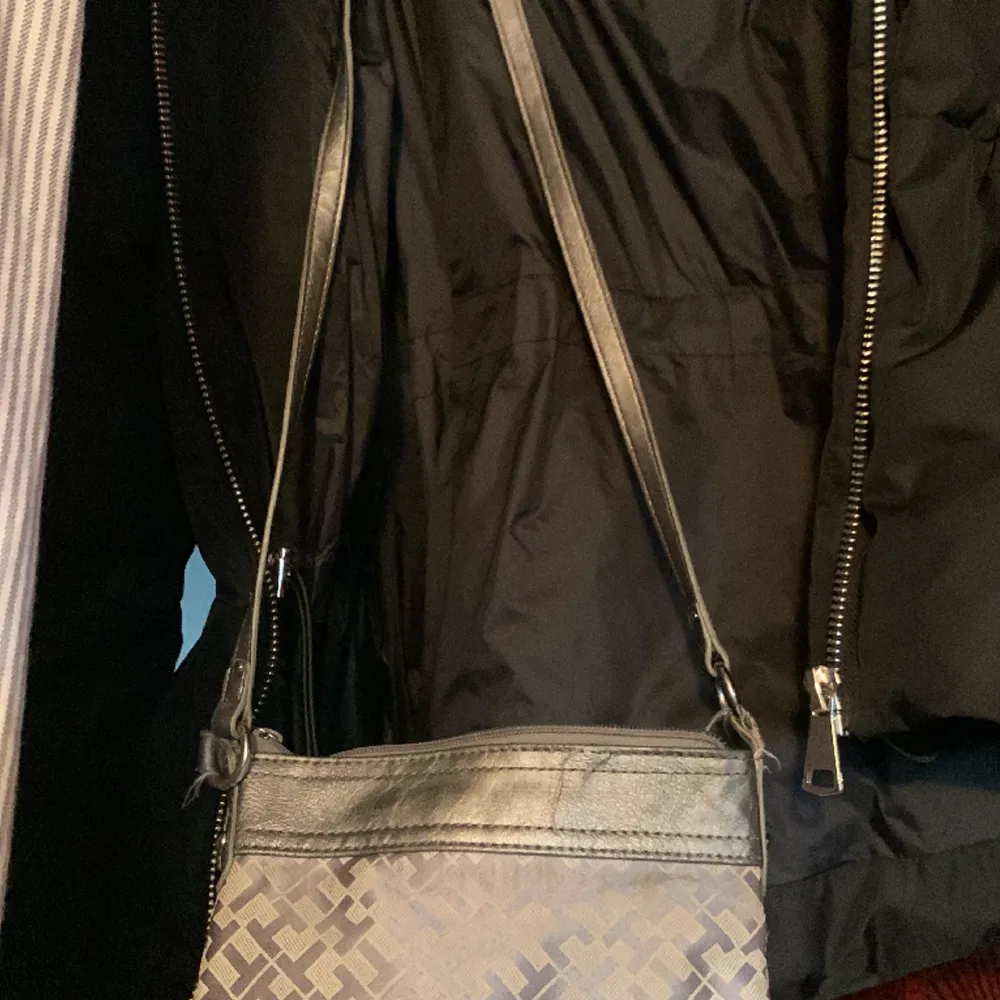 Väska Tommy Hilfiger  Sparsamt använd Färg silvergrå den rymmer det viktigaste som mobilen, nycklar samt plånboken . Säljer pga att jag har för många . Accessoarer.