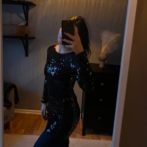 Glitter klänning  - Svart tajt glittrig klänning som går till knäna ungefär och är långärmad i ärmarna 