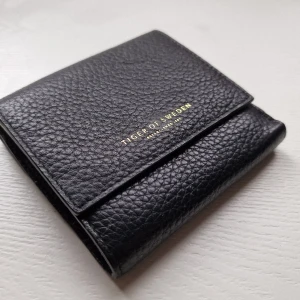 Plånbok Tiger of Sweden läder  - Jättefin plånbok från Tiger of Sweden. Är I äkta läder. Nästintill oanvänd. Många fickor och kortfack. 