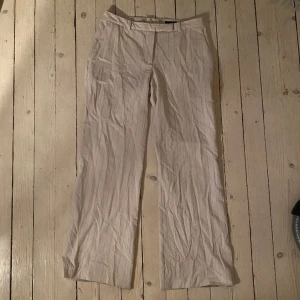 Kostymbyxor  - Raka Vaniljvita kostymbyxor med ränder. märket är hm. Dem är insydda i midjan sen jag köpte dem och passar mig som är st: 36/s perfekt lågmidjat. Jag är 168 och dem går ner till fötterna! (:  Obs:Säljer på flera hämsid,skriv vid intresse  för köp nu 