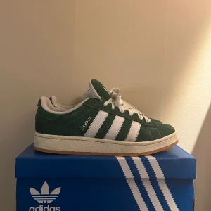 Adidas Campus 00s - Säljer nu ett par Adidas Campus 00s i nyskick. Köptes i slutet av 2023 och har använts ett fåtal gånger. Allt original medföljer, box och extrasnören (gröna). Kvitto kan lösas vid behov. Bara att höra av sig vid eventuella frågor eller funderingar!