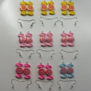 Karameller berlocker som örhängen  - Dessa är örhängen som jag gör själv. Ni bestämmer själva vilken färger ni vill ha. Men det finns bara de färger som är med på bilderna. Dessa är aldrig använda. Skriv till mig om du undrar något. OBS! När du köper denna kommer du endast köpa ett par!