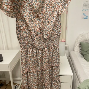 Super snygg blommig klänning  - Den är normal i storlek. Jag har sytt upp V ringningen då den var ganska djup. Använd bara en gång så inga slitningar. 