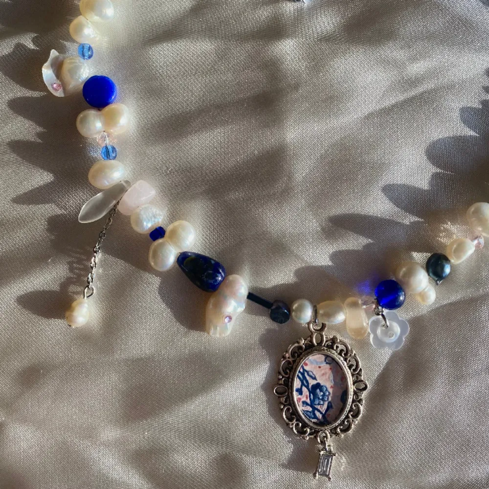 Halsband gjort av glaspärlor och sötvattenspärlor, med en berlock jag målat som en mini-version av en av mina målningar💙🌸 reglerbar längd 40-45.5cm  Kika in min instagram @flyingladybugz för mer smycken💗🐞. Accessoarer.