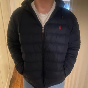 Ralph Lauren Jacka - Säljer min brors Ralph Lauren jacka då den va för stor. Jackan är helt ny! Den är i storlek XL vuxen och sann till storlek!!. I marinblå med ett rött tecken. Den har luva å fickor!☺️pris går att diskutera 