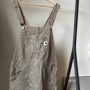 Carhartt hängselbyxor  - Riktigt fina hängselbyxor. Använda Max 3 gånger. Långa ben för den som är lång. Klipp och få en nice vintage känsla för kortare peps. 