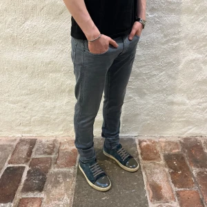 Replay Anbass jeans  - Replay anbass jeans i färgen grå. Storlek 31/32 och modellen på bilden är 182 cm. Fint skick, köp för endast 599kr