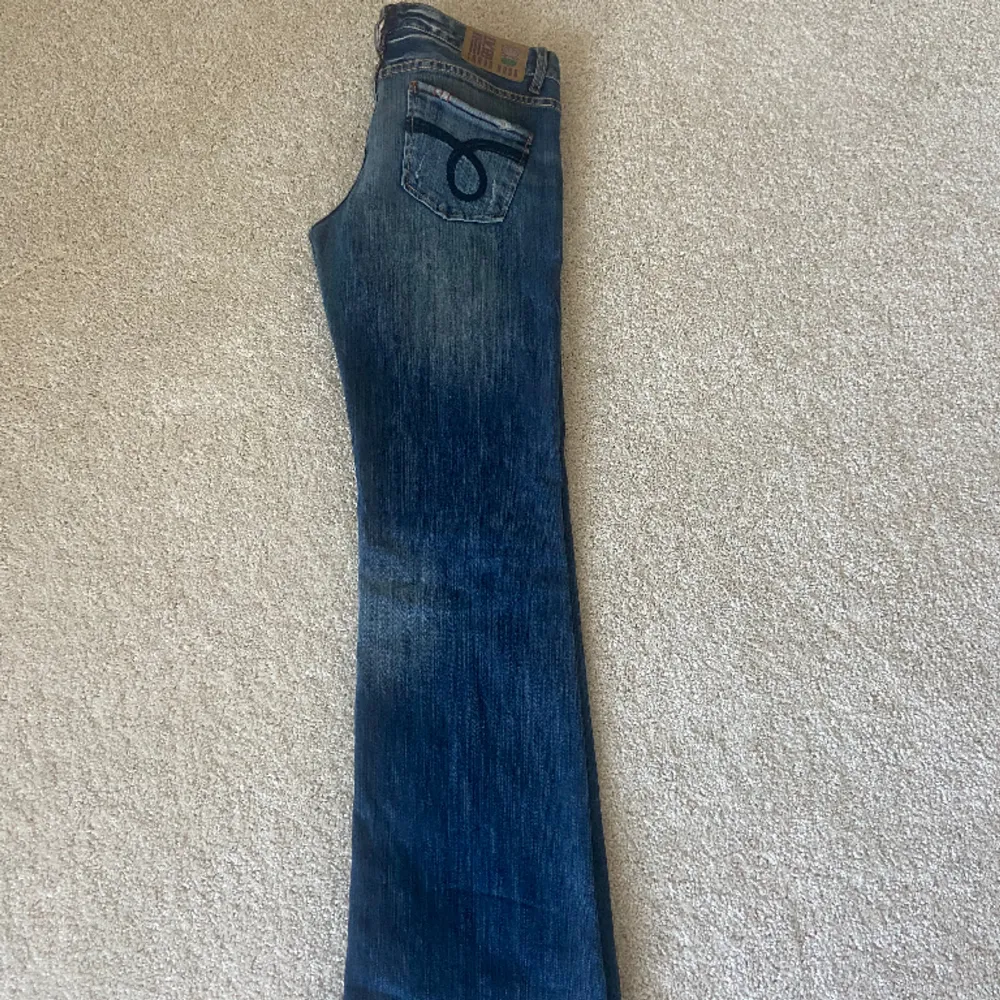 Lågmidjade jeans i en skitcool tvätt med slitningar. Passar mig i längden som är ca 170 cm.  Midjemått: 42 cm Ytterbenslängd: 102 cm Innerbenslängd: 79 cm. Jeans & Byxor.