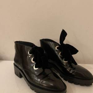 Lackade boots från Sandro Paris. Storlek 39 med söta sammetsrosettband