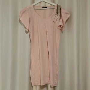 Glittriga rosa volang kläning - Säljer denna jätte fina glittriga rosa volang T-shirt klänning med coola detaljer vid axeln. Den är perfekt till massa tillfällen, pris går att diskuteras. Kan mötas vid diskuteras plats ❣️