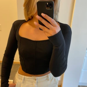 Svart topp - Fyrkantig urringning, aldrig använd. Obs inga fläckar på tröjan, soljusfläck/kamerafläck på bilden. 