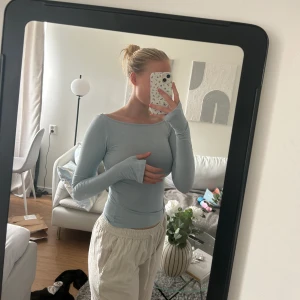 A-dsgn långärmad topp - En ljusblå långärmad topp från A-dsgn. Den har ett fantastiskt mjukt material, långa ärmar och hål för tummarna.  