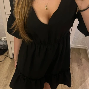 Svart klänning med öppen rygg - Hej, jag säljer en svart klänning från SHEIN med öppen rygg. Klänningen är helt oanvänd och i bra skick. Den har tyvärr bara legat i min garderob och inte kommit till användning. Klänningen är dock väldigt vacker och fint med öppen rygg.