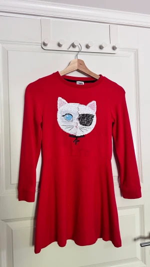 Karl lagerfeldt klänning - Klänning med paljettdetalj som går att ändra. Finns en liten fläck under trycket, men är inte särskilt synligt. OBS! STORLEK FÖR BARN!