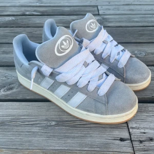 Säljer ett par gråa Adidas Campus 00s! - Hej!  Säljer dessa supersnygga gråa och vita Adidas Campus 00s. Dem har används några fåtal gånger och har inga fläckar eller defekter! Priset kan diskuteras. Hör av dig vid minsta intress!