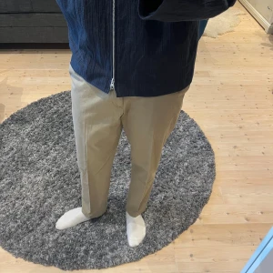 Uniqlo chinos - Helt nya och oanvända chinos som fortfarande har kvar pris/info-lapp. Mycket bra skick.  Lite stretch och vidare passform. Har snörning som döljs på insidan runt midjan så de går att justera och använda utan skärp.  Storlek L/31 Waist 84-92cm