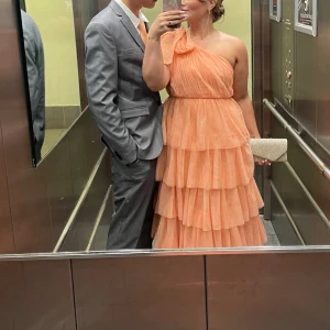 Balklänning  - Säljer min älskade balklänning som är aprikosfärgad så den kan användas igen, storlek 34 men passade mig som har 38🧡🧡 har ett litet hål på en volang på sidan som inte synsa alls, finns även en slips att köpa till som matchar.