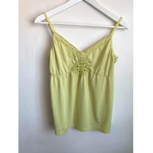 Ljusgrönt somrigt linne, 42/44 M/L, virkad, spets, bohemisk, boho, spagetti, v-ringad - Limegrönt linne med virkade detaljer, observera att det är öppet fram vid broderiet, justerbara axelband. Det finns noppor över hela linnet och det har trådat sig lite högst upp på höger sida. Mått får ej plats - fråga gärna!