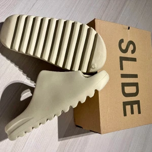 Yeezy slides (bone) - Hej! Jag säljer nu mina Yeezy slides bone. Dom är i ett väldigt bra skick. Jag har tyvär inte hunnit använda dom mer än förra sommaren eftersom att dom nu inte passar mig. Skriv till mig om du undrar något. Mvh Jonathan 