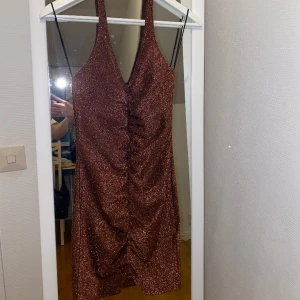 Glittrig Brun Klänning - Kort och Glittrig Brun klänning som sitter jätte bra! Super fin färg.  Är i storlek S och bara använd en gång!