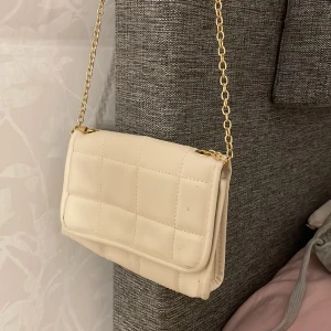 Liten väska - Jättefin beige väska från shein. Använd några gånger. Den är mindre än vad den ser ut på bild, måtten är 20x15cm. Går även att förlänga kedjorna. Passar fint till studenten också!