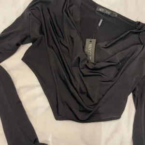 Svart topp - Oanvänd topp från Nelly, går att ha one shoulder också!