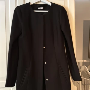 Kappa - Svart kappa i storlek Xs.