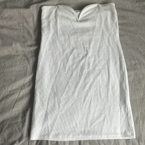 Hm klänning - En super fin vit klänning från H&M utan band, passar till sommaren när man är brun!!