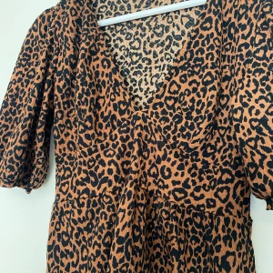 Topp med leopardmönster - En gullig topp med leopardmönster, den har typ volanger längst ner. Har använts en gång men är som ny. Köparen står för frakt