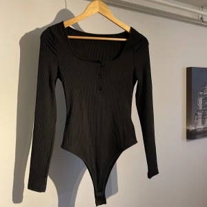 Svart långärmad body tröja  - Svart långärmad body tröja med tre knappar, aldrig använd! Kontakta innan köp!