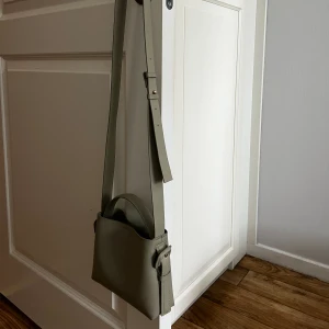 Arket - esk Ljusgrön Väska  - Arket - esk crossbody väska i superfin ljus olivgrön färg som passar perfekt till våren / sommaren 💚 Rymlig och i så gott som ny skick på både utsida och insida. Orginalpris 349 kr , säljs 200 kr 💚