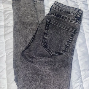 Gråa lågmidjade jeans - Tighta o lågmidjade jenans i stolek 34 men skulle vilja säga att den mer passar 32 ! 