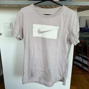Nike t-shirt - Lite kortare fram än bak. Smutsrosa färg. Ok skick, inga större defekter.   Katt finns i hemmet. 