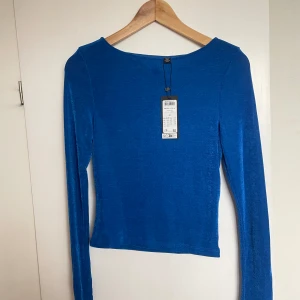 Blå topp - Blå skimrig topp från Bik bok, aldrig använd med prislapp kvar. 