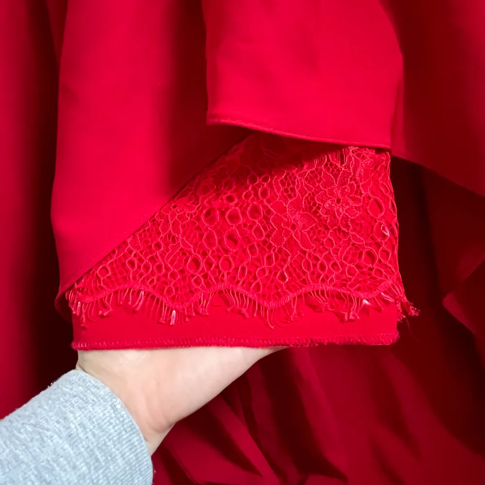 En röd balklänning (maxi) med snitt. Som ni kan se på andra bilden har klänningen en fin detalj med spets på bensnittet.. Klänningar.