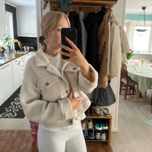 Supermjuk teddyjacka! - Lagom varm inför våren! Med två bruna knappar över brösten, jag är 171 lång och jackan slutar precis över rumpan. 