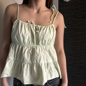 Lime grön topp  - Trendig lime grön topp. Passar perfekt nu till sommaren! Str 40 men passar även mig som är S/Xs, som du ser på bilden. Har band som är justerbara❤️går inte längre att köpa i butik
